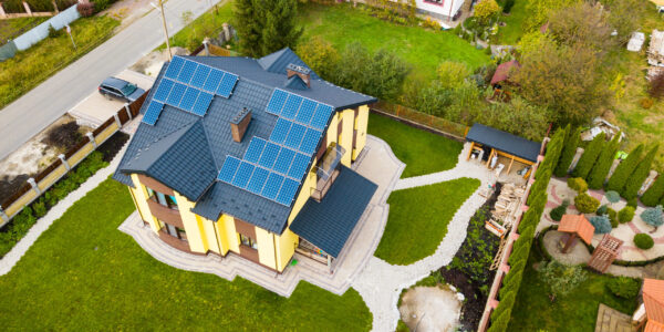 Aerial view of a private house with solar photovoltaic panels for producing clean electricity on roof. Autonomous home concept.