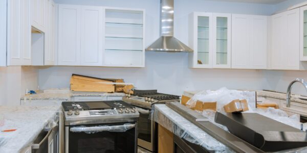 Interior of modern kitchen with all appliances on stove top, marble counter with kitchen white cabinets